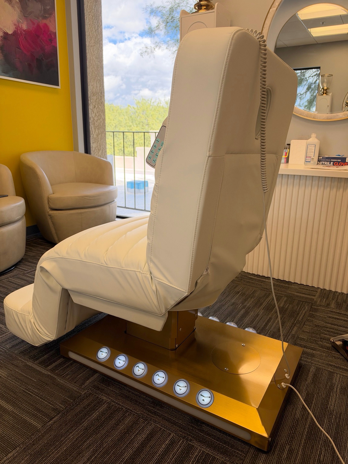 Reclining treatment chair beside a sunlit clinic window