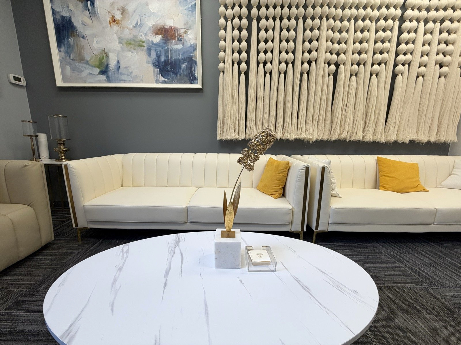 ZuVida waiting room with ivory seating, blue-gray walls, gold accents, and plants